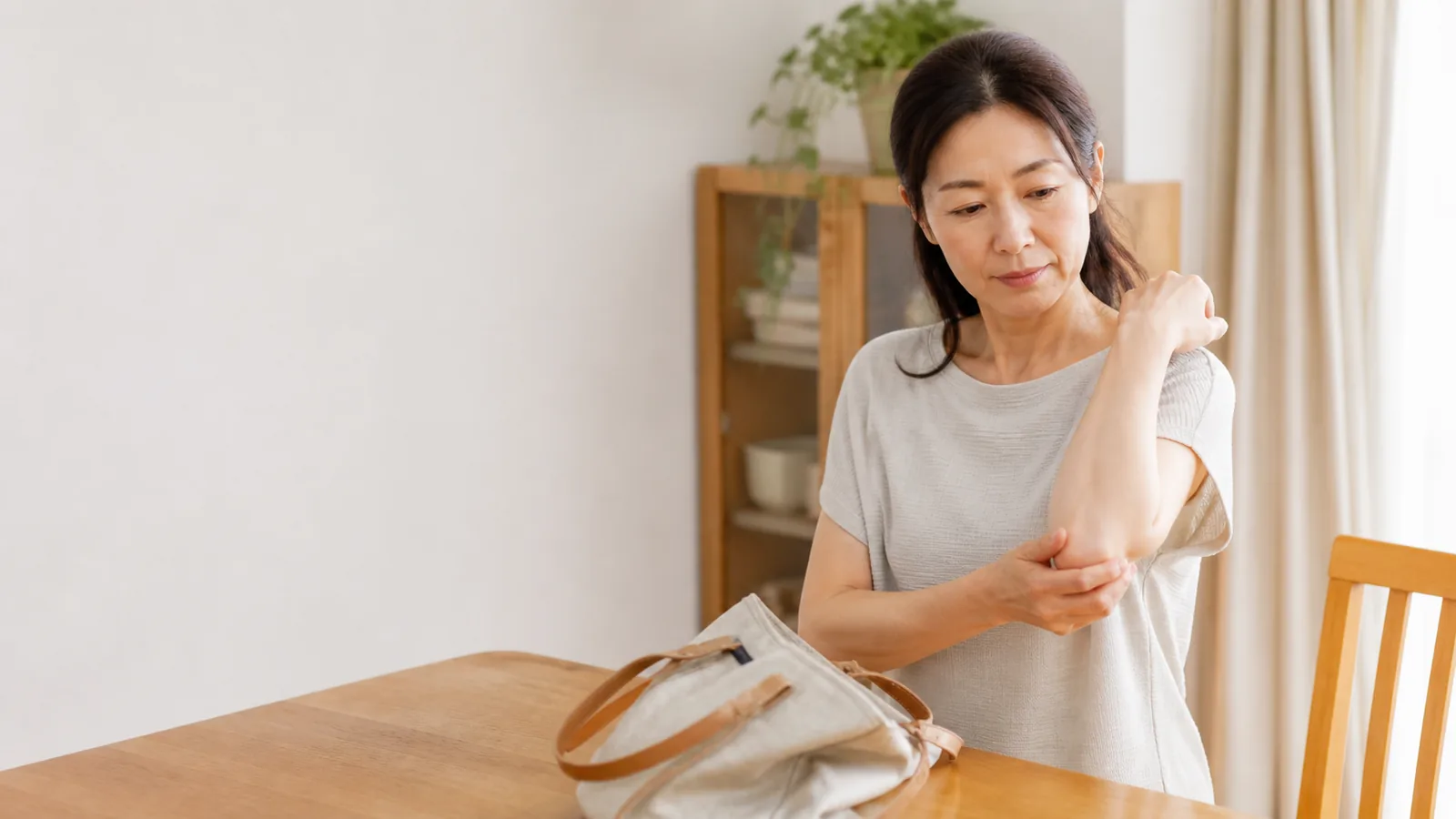 東亞女性在家中輕觸手肘