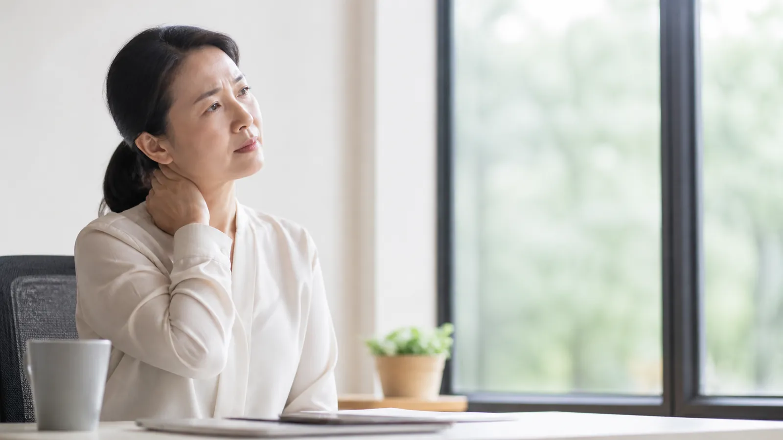 東亞女性在工作時輕觸頸部